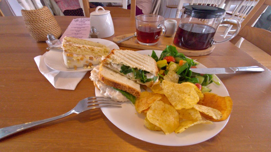 A chicken and bacon toastie, a slice of caramel cake, and a pot of tea.
